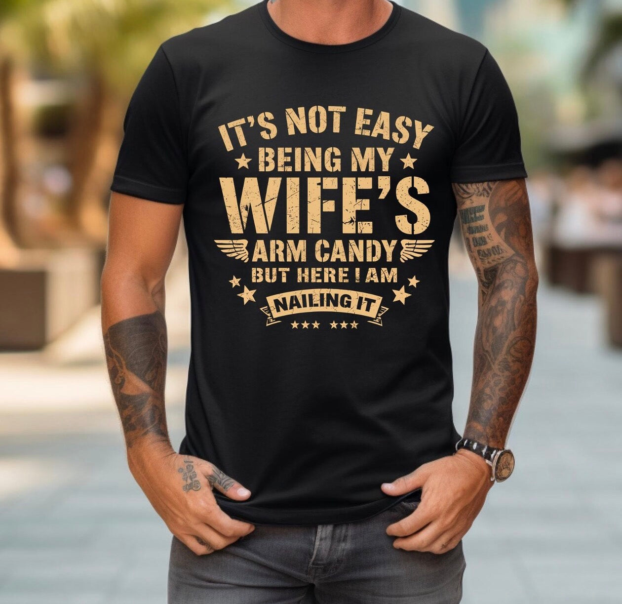 Funny Husband Shirt – It’s Not Easy Being My Wife’s Arm Candy But Here I Am Nailing It | Father’s Day Gift for Dad | Christmas Gift for Husband | Men’s Graphic Tee