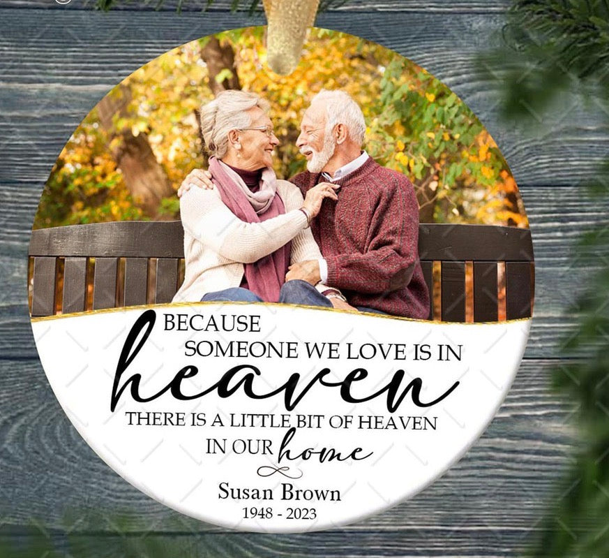 Personalized round memorial ornament featuring a couple’s photo and the quote “Because someone we love is in heaven, there is a little bit of heaven in our home.”