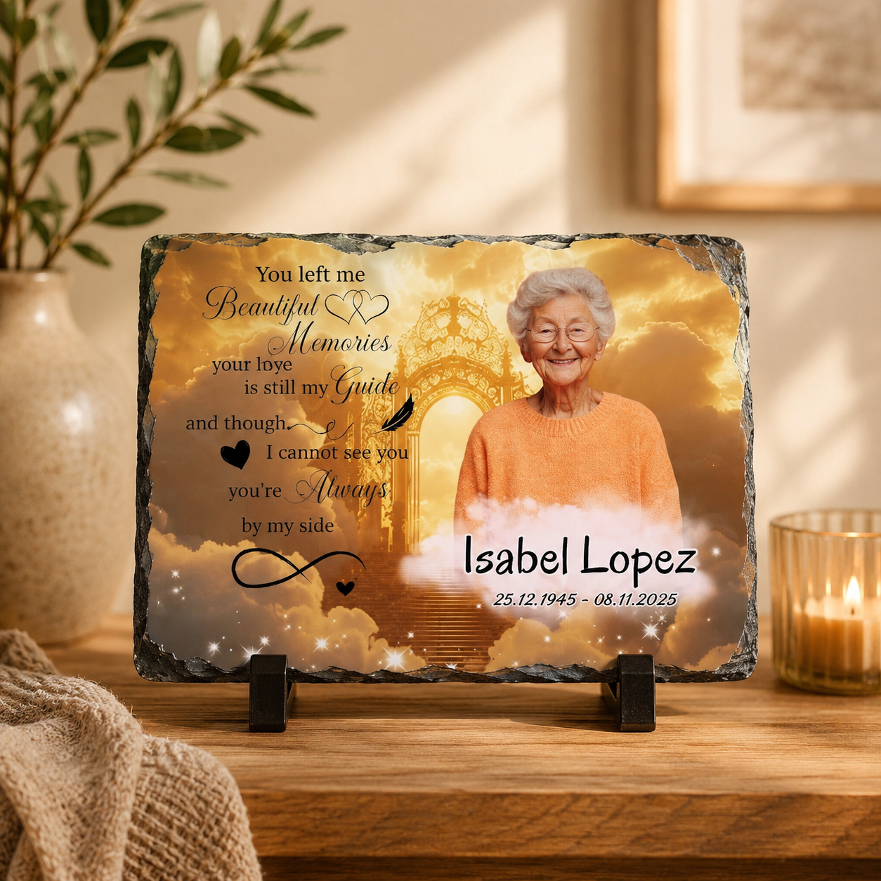Personalized memorial slate plaque on a wooden table, featuring a photo of an elderly woman, golden clouds, stars, and memorial text reading 'You left me Beautiful Memories your love is still my Guide.