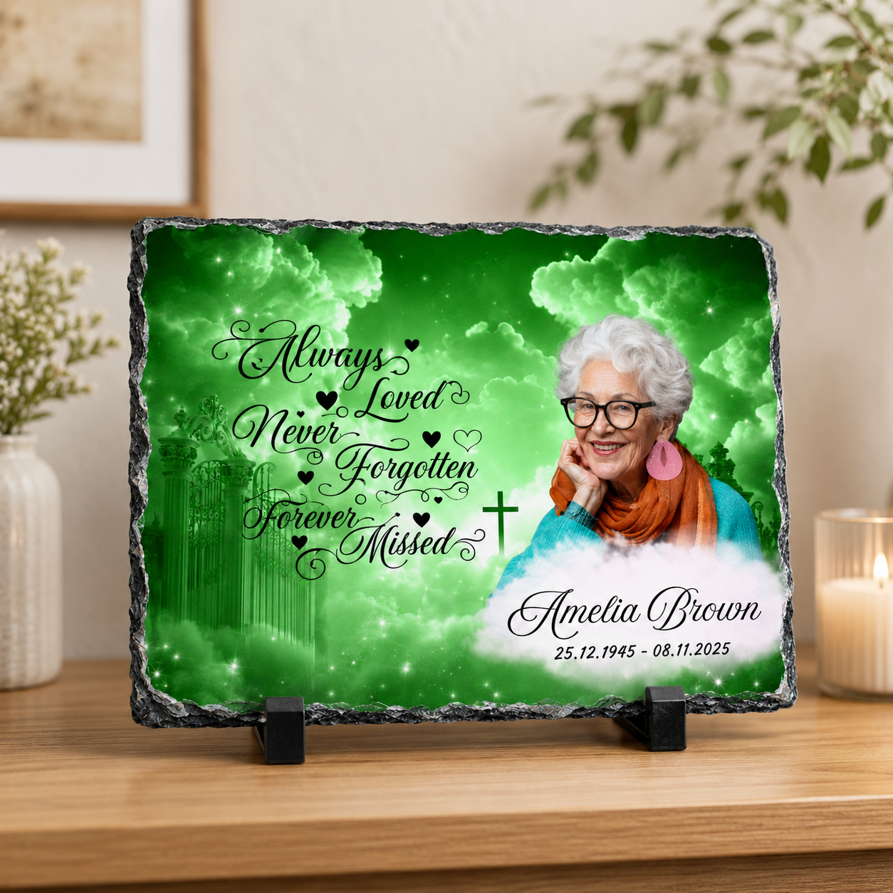 Personalized memorial slate plaque on a wooden table in a home setting, featuring a green cloudy background, a portrait of an elderly woman, and the text 'Always Loved Never Forgotten Forever Missed' with the name 'Annetta Brown' and dates.