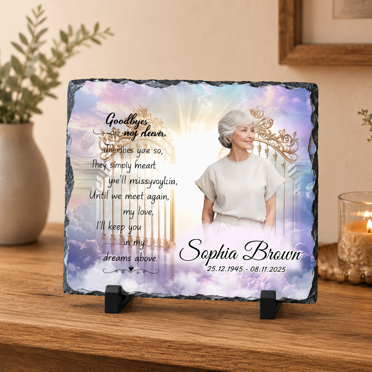 Personalized memorial slate plaque on a wooden table, featuring a portrait of a woman, a glowing gate, clouds, and the text 'Goodbye to my dear Sophia Brown' with dates, displayed in a home setting.